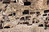 Touristen erkunden die antike Höhlenstadt Vardzia, Georgien, Zentralasien, Asien