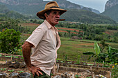 Tobacco plantation worker with cigar, on valley ridge, Vinales, Cuba, West Indies, Caribbean, Central America