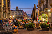 View of busy street near Piazza dell'Universita (University) at dusk, Catania, Sicily, Italy, Mediterranean, Europe