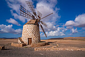 Blick auf eine traditionelle Windmühle und Landschaft an einem sonnigen Tag, La Oliva, Fuerteventura, Kanarische Inseln, Spanien, Atlantik, Europa