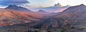 Blick auf Straße und Berge vom Astronomischen Aussichtspunkt Sicasumbre bei Sonnenuntergang, Pajara, Fuerteventura, Kanarische Inseln, Spanien, Atlantik, Europa
