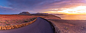 Blick auf Straße und Vulkanküste vom Mirador del Rio bei Sonnenuntergang, Lanzarote, Las Palmas, Kanarische Inseln, Spanien, Atlantik, Europa