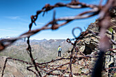 Mädchen wurde von Überresten des Ersten Weltkriegs im Gavia-Tal, Valtellina, Provinz Sondrio, Lombardei, Italien, Europa eingerahmt