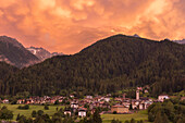 Sonnenuntergang über dem Dorf Ossana mit Mammatus-Wolken, Sole-Tal (val di Sole), Provinz Trient, Trentino-Südtirol, Italien, Europa