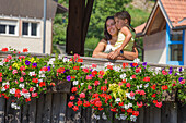 Mutter und Tochter umarmen sich und schauen auf das Panorama von der Holzbrücke (Ponte di Legno di Pellizzano) im Sommer, Pellizzano, Tal der Sole (val di Sole), Provinz Trient, Trentino-Südtirol, Italien, Europa (MR)