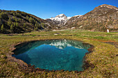 das blaue Loch in der Nähe von Madesimo mit dem Berg Pizzo Spadolazzo im Hintergrund, Orobie-Alpen, Valtellina, Gemeinde Madesimo, Provinz Sondrio, Region Lombardei, Italien, Europa