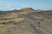 Luftaufnahme der Straße in der Nähe des Vulkans Caldera Colorada, Lanzarote, Kanarische Insel, Spanien, Europa, per Drohne