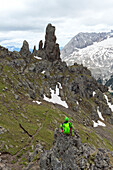 Ein Wanderer rastet auf dem Klettersteig Via Ferrata delle Trincee, Padon-Gruppe, Dolomiten, Fassa-Tal, Provinz Trient, Trentino-Südtirol, Italien.