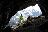 Ein Wanderer bewundert den Gran Vernel am Ausgang einer Kriegsgalerie am Klettersteig Via Ferrata delle Trincee, Padon-Gruppe, Dolomiten, Fassa-Tal, Provinz Trient, Trentino-Südtirol, Italien.