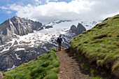 Ein Wanderer auf dem Weg Viel del Pan mit der Marmolada im Hintergrund, Padon-Gruppe, Dolomiten, Fassatal, Provinz Trient, Trentino-Südtirol, Italien.