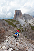 Zwei Wanderer auf dem Klettersteig Roda di Vael, mit dem Sforcella im Hintergrund, Dolomiten, Rosengartengruppe, Fassatal, Provinz Trient, Trentino-Südtirol, Italien