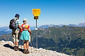 Couple of retirees heading off on a hike on the heights of the weisshorn in the swiss alps, active seniors, tourism, resort of arosa, canton of the grisons, switzerland