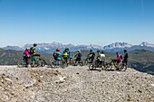 Mountain bikers heading off on a trek on the heights of the weisshorn in the swiss alps, active seniors, tourism, resort of arosa, canton of the grisons, switzerland