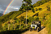 Landschaft, Jeep und Regenbogen in der Nähe von Kaffeeplantagen