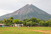 People playing soccer game at the foot of the volcano, Ometepe island, Nicaragua