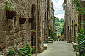 Charakteristische Gasse, geschlossen zwischen hohen Tuffsteinhäusern, mit Blick auf das Tal des alten Dorfes Pitigliano. Pitigliano, Provinz Grosseto, Toskana, Italien, Europa