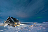 Europe, Norway, Finnmark, Kongsfjord, Veidnes, Blue house and aurora borealis