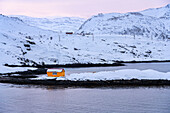 Europe, Norway, Soroya island, Yellow house in a fjord
