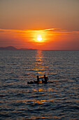 Italien, Toskana, Punta Ala, Cala Civetta, Zwei Personen im Kajak bei Sonnenuntergang