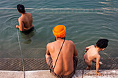 pilgrims bathing in the sacred pool Amrit Sarovar, Golden temple, Amritsar, Punjab, India