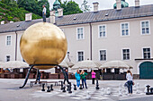 Die Goldene Sphäre von Stephan Balkenhol und Schachspieler, Salzburg, Österreich