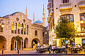 Outdoor terrace of Place de l'Etoile Cafe, bar, restaurant and facades of Saint George Greek Orthodox Cathedral and Mohammad Al-Amin Mosque, in El Nejmeh square or Star square, Downtown, Beirut, Lebanon