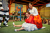 Lucha Libre. Combat between Dina with orange skirt and Benita la Intocable , cholitas females wrestlers ,with referee, Sports center La Ceja, El Alto, La Paz, Bolivia