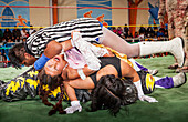 Lucha Libre. Julieta und Celia la Simpatica mit rosa Rock während eines verrückten Kampfes, gegen männliche Wrestler, Sportzentrum La Ceja, El Alto, La Paz, Bolivien