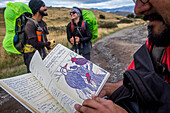 Wanderer zeigt Wildtiernotizen über Pato Cortacorrientes, Merganetta armata, in der Nähe der Chileno-Hütte, Torres del Paine Nationalpark, Patagonien, Chile