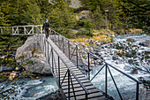 Hiker crossing Ascencio river, near Chileno refuge, Torres del Paine national park, Patagonia, Chile