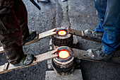 Takahiro Koizumi and his assistant Kohei ishimori are waiting that solidify the molten iron inside the molds, to make a iron teapot or tetsubin, nanbu tekki,Workshop of Koizumi family,craftsmen since 1659, Morioka, Iwate Prefecture, Japan