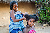Young girls, friends arranging their hair, small town in the Tsingy de Bemaraha National Park. Madagascar, Africa