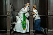 woman and priest, confession, in Basilica of Our Lady of Candelaria, Medellín, Colombia