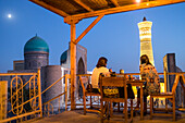 Minor Cafe House. At right Kalon minaret and mosque. At left Mir-i-Arab medressa , Bukhara, Uzbekistan