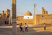 Kids playing football, street scene in Ichon-Qala, old city, Khiva, Uzbekistan