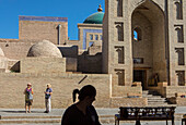 Street scene in Ichon-Qala, old city, at right main gate of Pahlavon Mahmud Mausoleum, Khiva, Uzbekistan