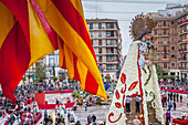Men placing flower offerings on large wooden replica statue of Virgen de los Desamparados, Fallas festival,Plaza de la Virgen square,Valencia