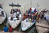 Pilger bereit in einem Boot zu segeln und zu beten, in Ganges-Fluss, Varanasi, Uttar Pradesh, Indien.