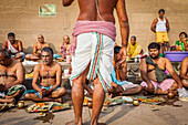 Pilger, die eine rituelle Opfergabe darbringen und beten, Ghats im Fluss Ganges, Varanasi, Uttar Pradesh, Indien.
