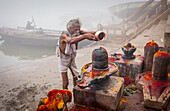 Pilgrim making a ritual offering and praying, ghats of Ganges river, Varanasi, Uttar Pradesh, India.