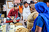 Man selling sweets. Candy store or confectionery, in Gotam Nagar street (main street),Historical Center,Vrindavan, Mathura, Uttar Pradesh, India