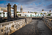 Puente de Las Bolas bridge, in backgrount, bell tower of church San Gines and town hall, Lanzarote, spain
