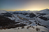 Blick vom Crap del la Parè auf Livigno und die umliegenden Berge bei Sonnenuntergang im Winter, Sondrio, Valtellina, Lombardei, Italien, Südeuropa