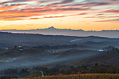 Schloss Grinzane Cavour beleuchtet bei Sonnenuntergang und Monviso in der Ferne, Cuneo, Langhe e Roero, Piemont, Italien, Südeuropa