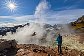 Tourist beobachtet die Berge von Landmannalaugar und Sulfatdampf im Sommer, Landmannalaugar, Hochland, Island, Nordeuropa (MR)