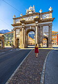 A woman in front of Triumphpforte, Innsbruck, Innsbruck-land, Tyrol, Austria, Western Europe