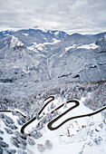 Luftaufnahme der kurvenreichen Straße des Presolana-Passes und des Pizzo Camino nach einem Winterschneefall. Presolana-Pass, Colere, Seriana-Tal, Provinz Bergamo, Lombardei, Italien.