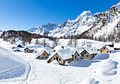 Die kleine Stadt Crampiolo und der Monte Cervandone an einem Wintertag, Alpe Devero, Antigorio-Tal, Piemont, Italien.
