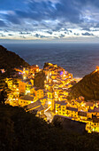 Die Lichter des Fischerdorfs Vernazza mit der typischen Krippe auf dem Hügel, Nationalpark Cinque Terre, Provinz La Spezia, Ligurien, Italien.