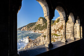 View of the sea and Monte Muzzerone from a rocky window near the church of San Pietro, Porto Venere, La Spezia district, Liguria, Italy.